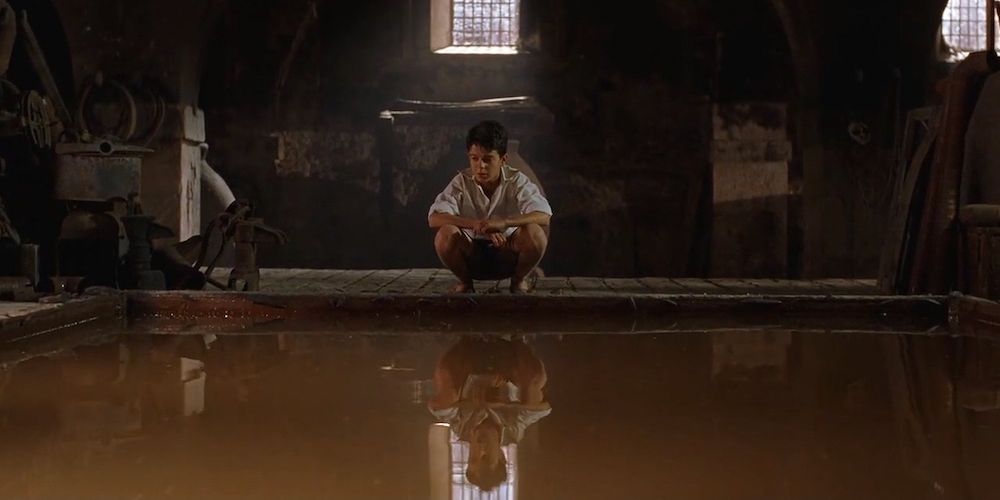 A boy looks into a pool of water in Guillermo del Toro's The Devil's Backbone