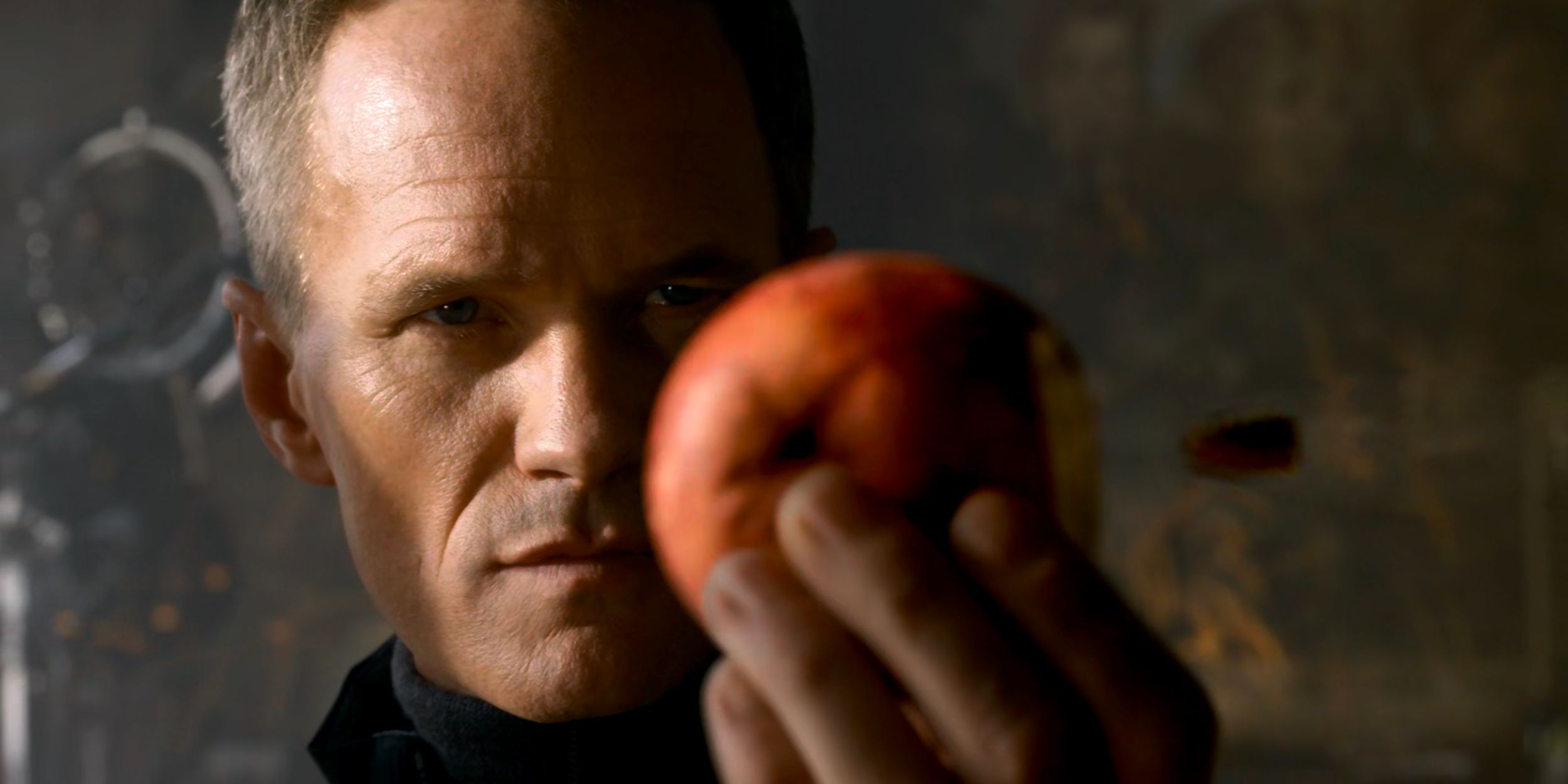 The Analyst (Neil Patrick Harris) holding an apple aloft as a bullet speeds towards it in slow motion.