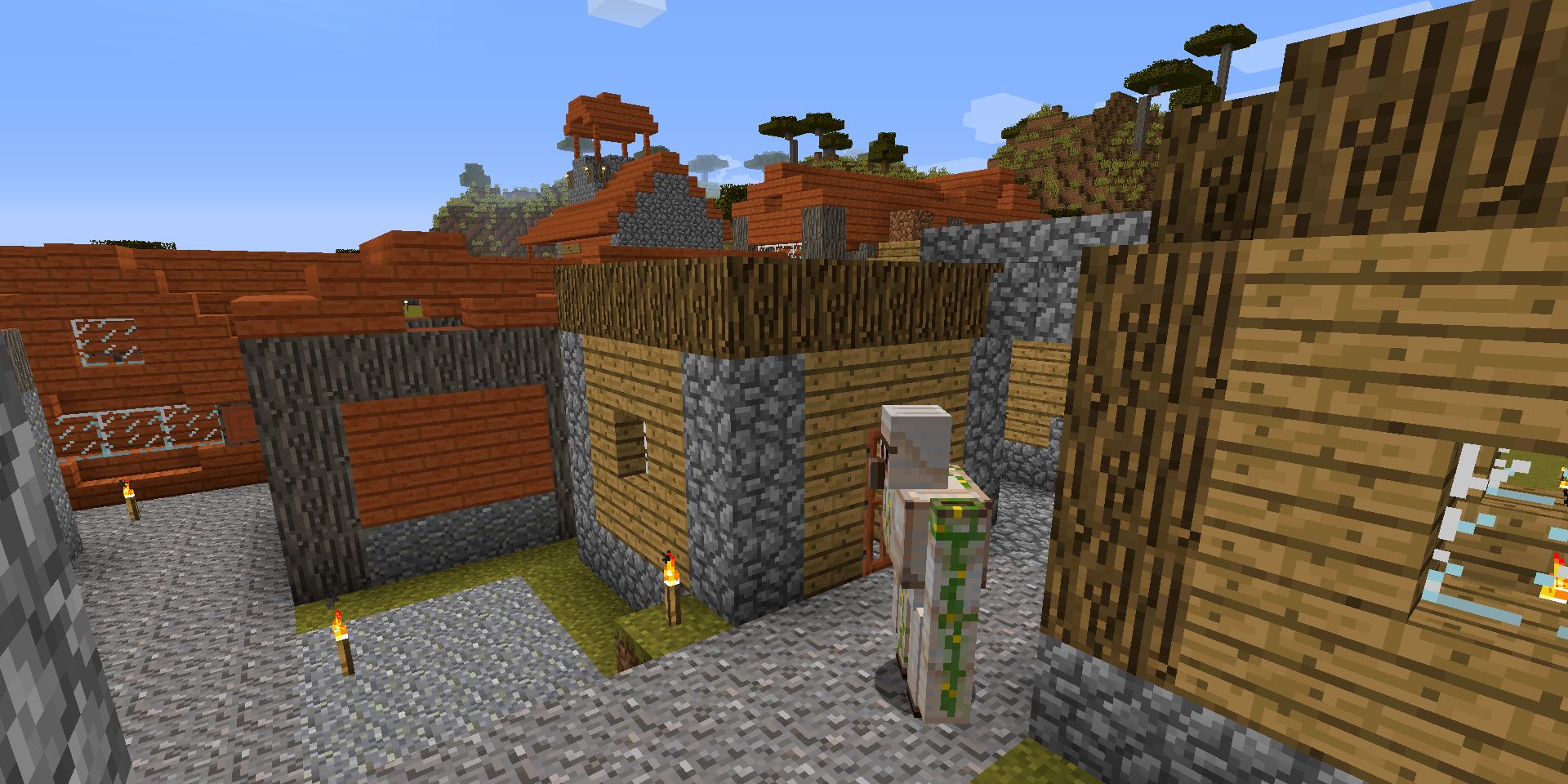 In-game screenshot of an Iron Golem in a village in Minecraft.