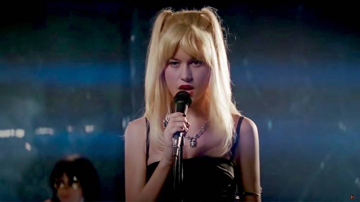 Envy Adams, una estrella de rock rubia que canta en el escenario.