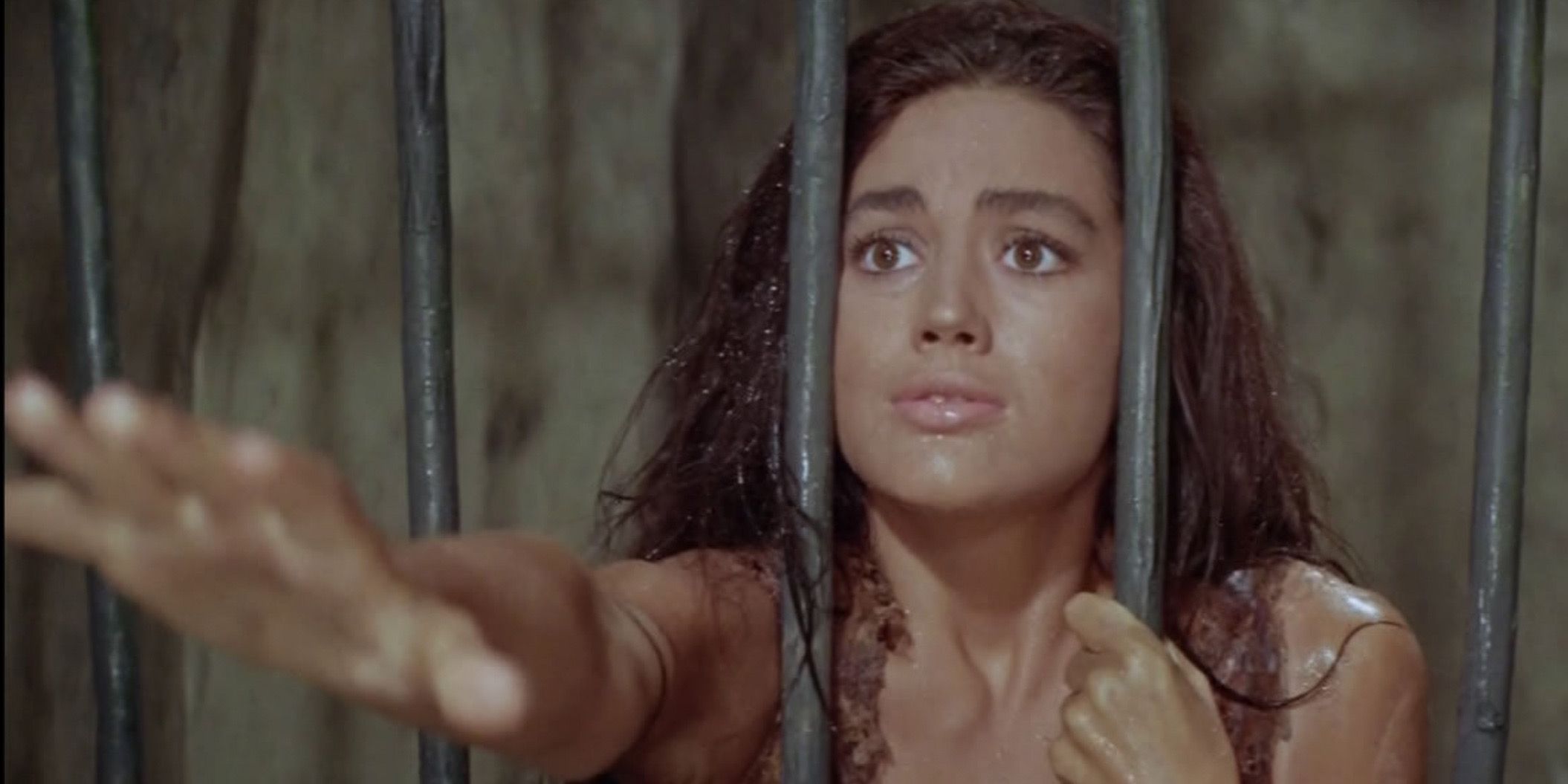 Nova reaches through the bars of a prison in Planet of the Apes (1968)