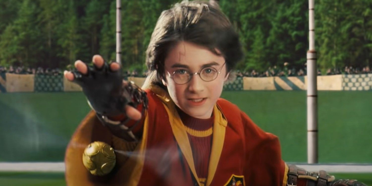 Harry Potter reaching for the golden snitch in a game of Quidditch in Harry Potter and the Sorceror's Stone.