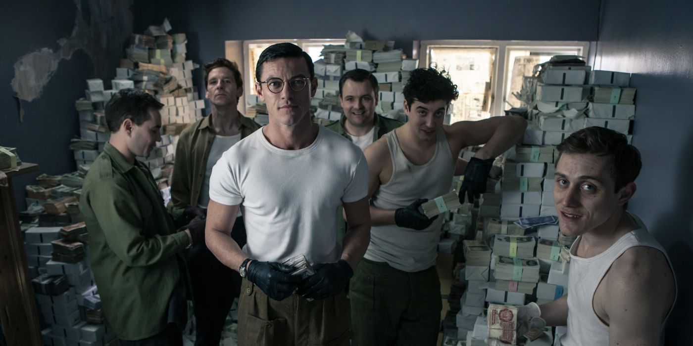 Bruce Reynolds (Luke Evans) dahil olmak üzere bir soyguncu ekibi, BBC'nin Büyük Tren Soygununda (2013) nakit yığınları arasında tasvir edilmektedir.