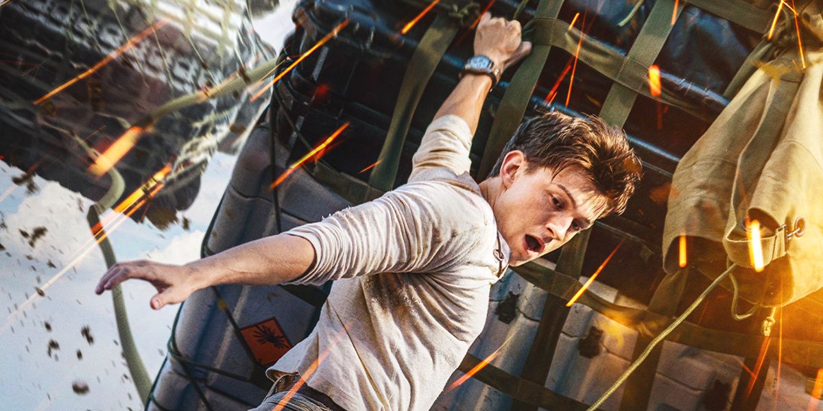 Tom Holland as Nathan Drake hangs from a plane in Uncharted movie