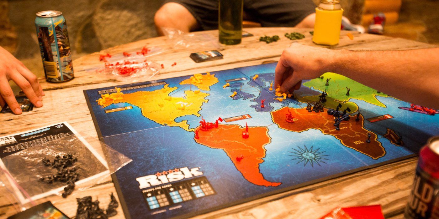 risk board game set up with drinks in the background