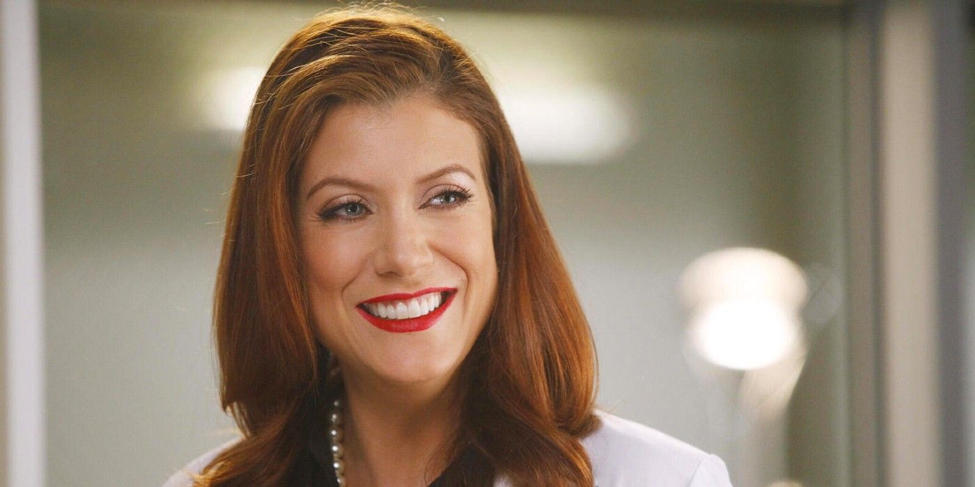 Addison Montgomery smiling in a lab coat in a hospital hallway