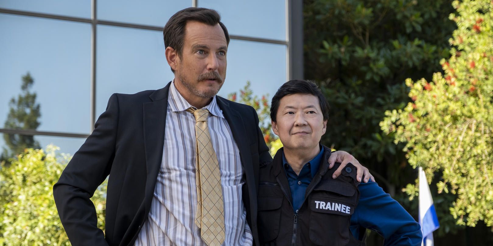 Ken Jeong and Will Arnett stand in front of a building