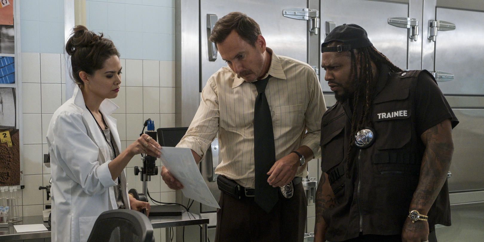 Marshawn Lynch and cast examine evidence in a scene from Murderville