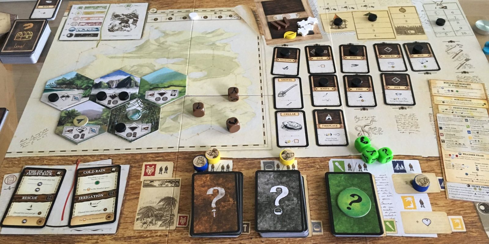 The components of an in-progress game of Robinson Crusoe board game