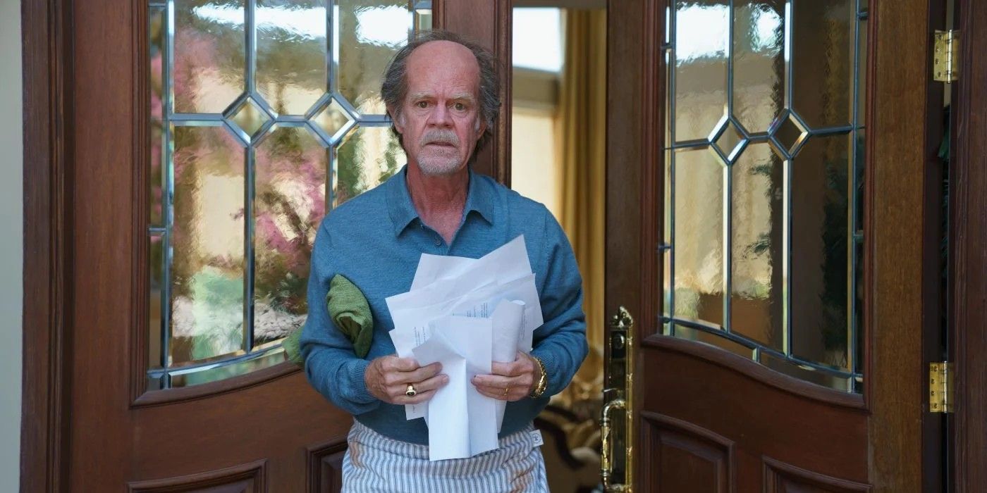 Disheveled William H. Macy in front of door holding papers