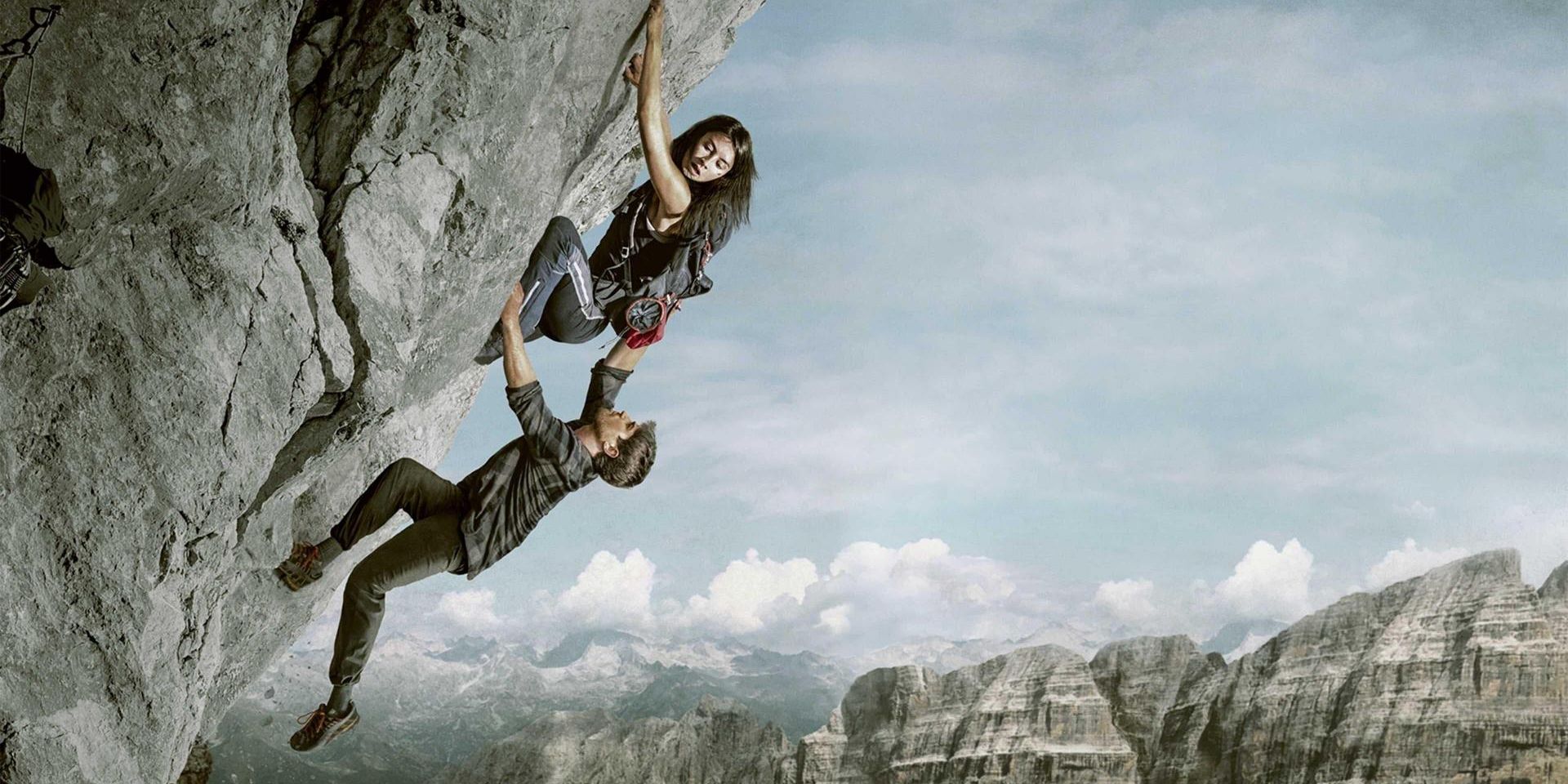 Two rock climbers on vertical cliff