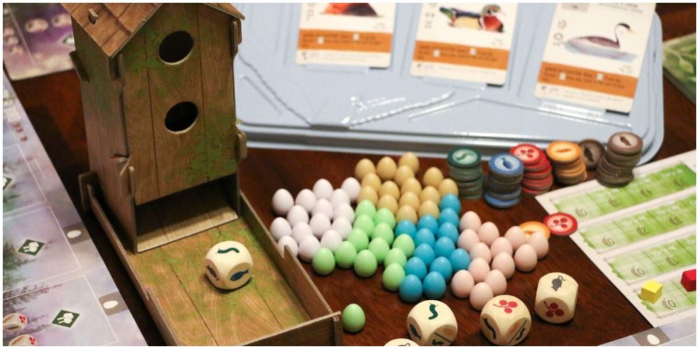 The dice roller, eggs, and food tokens of Wingspan board game.