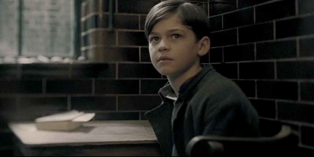 Hero Fiennes-Tiffinas a young Tom Riddle, looking up from a desk  In The Half-Blood Prince.