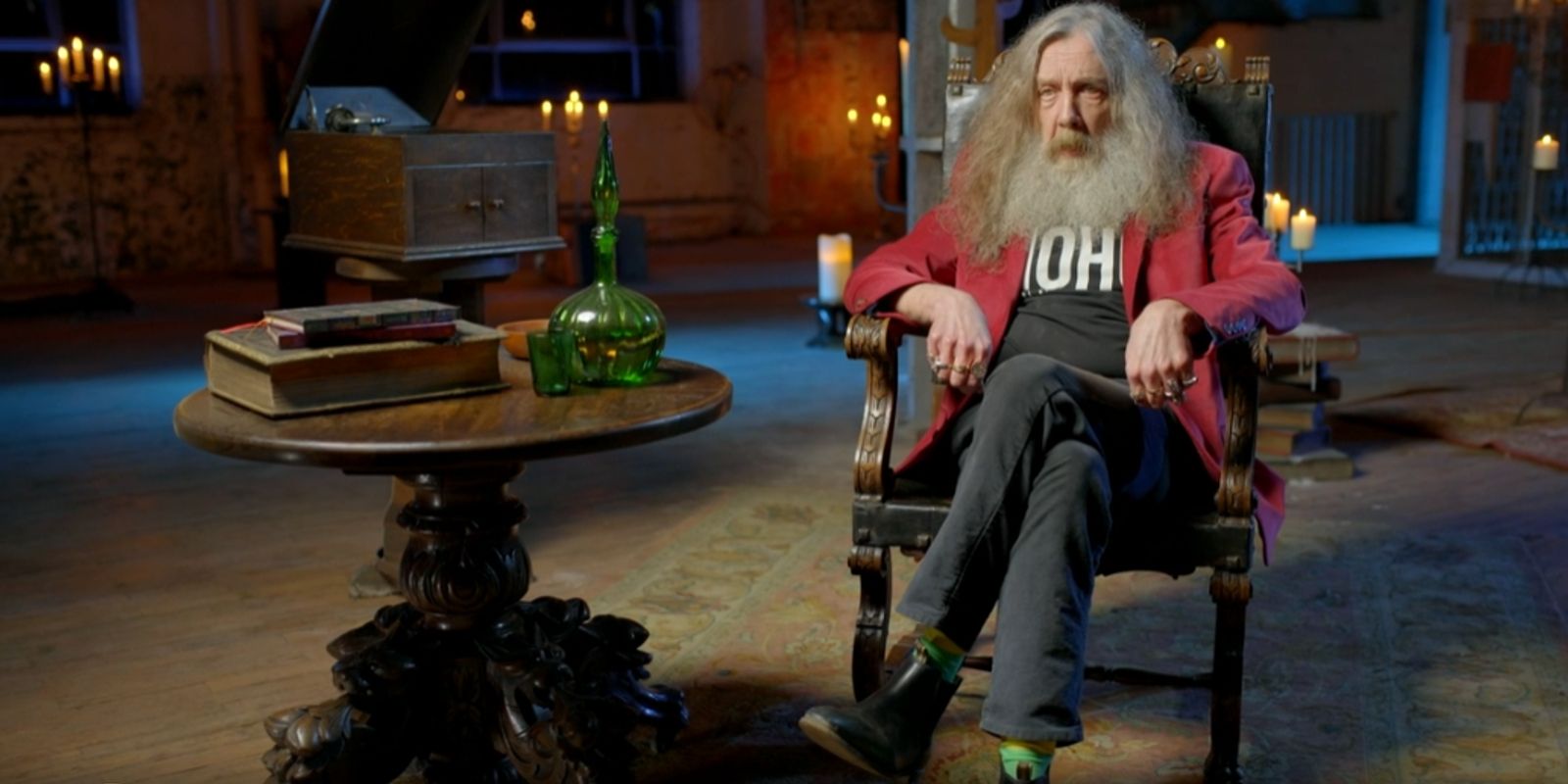 Alan Moore sitting in a chair header