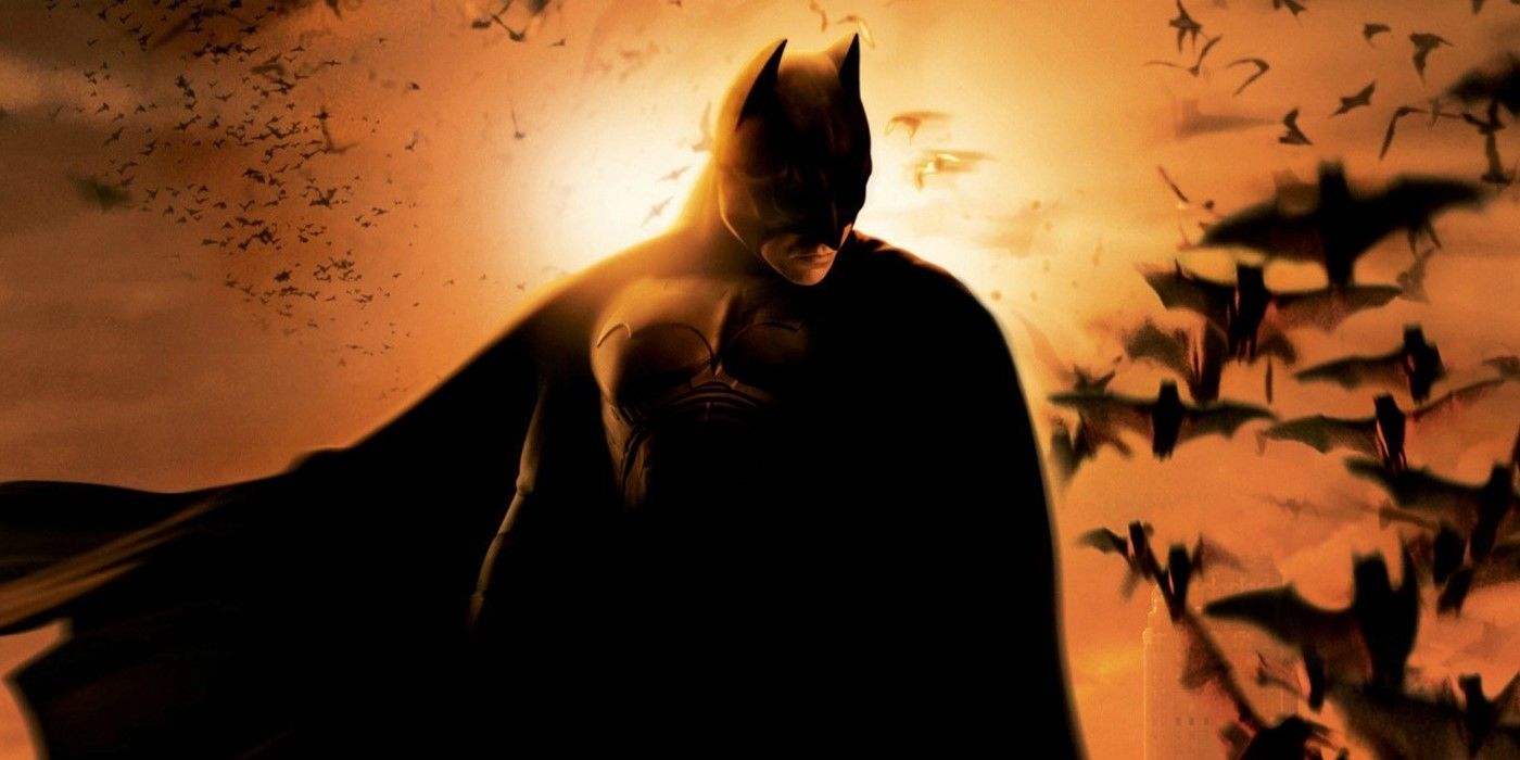 Batman debout contre le soleil couchant et un essaim de chauves-souris dans Batman Begins. 