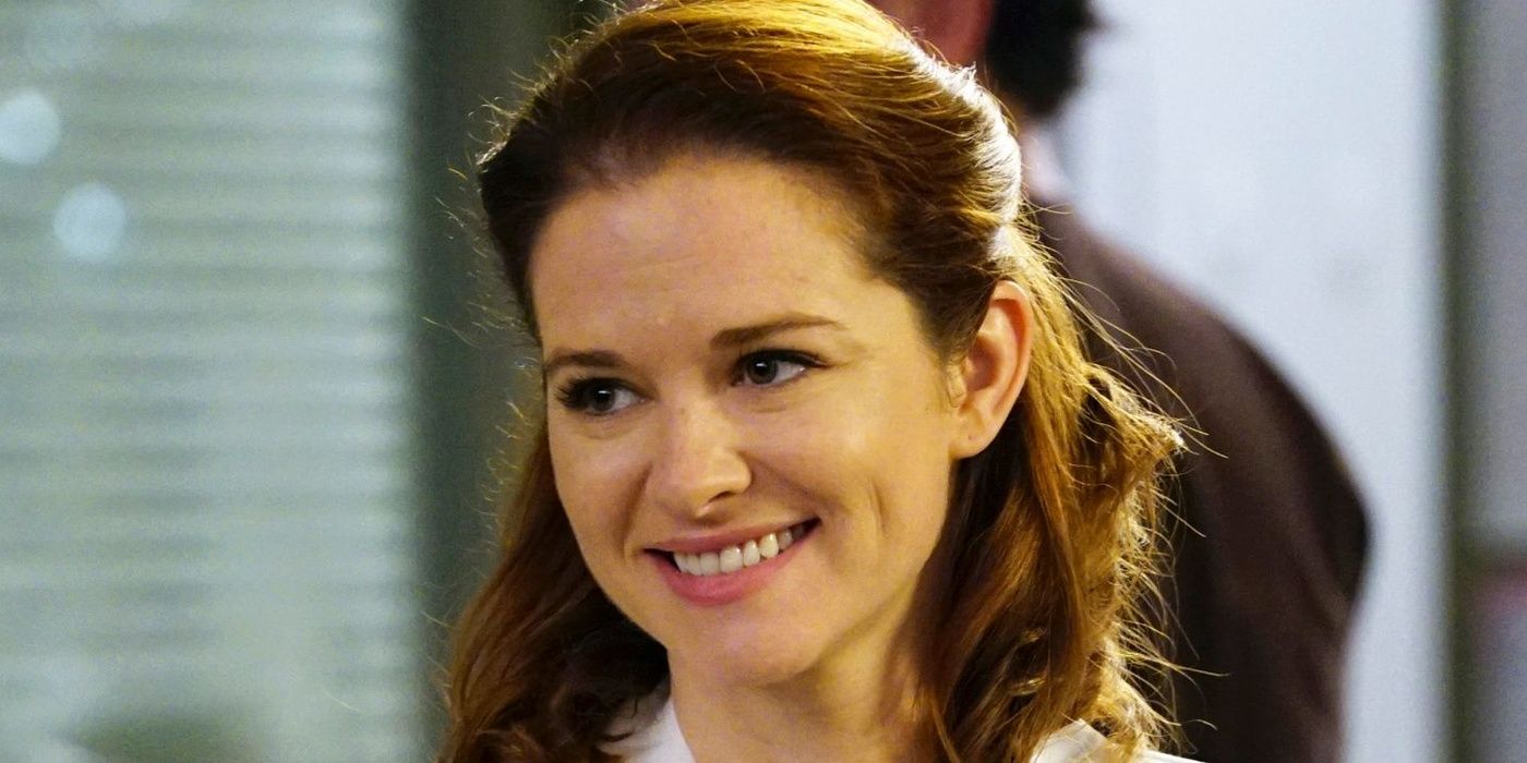 Sarah Drew plays Dr. April Kepner smiling in the hospital on Grey's Anatomy