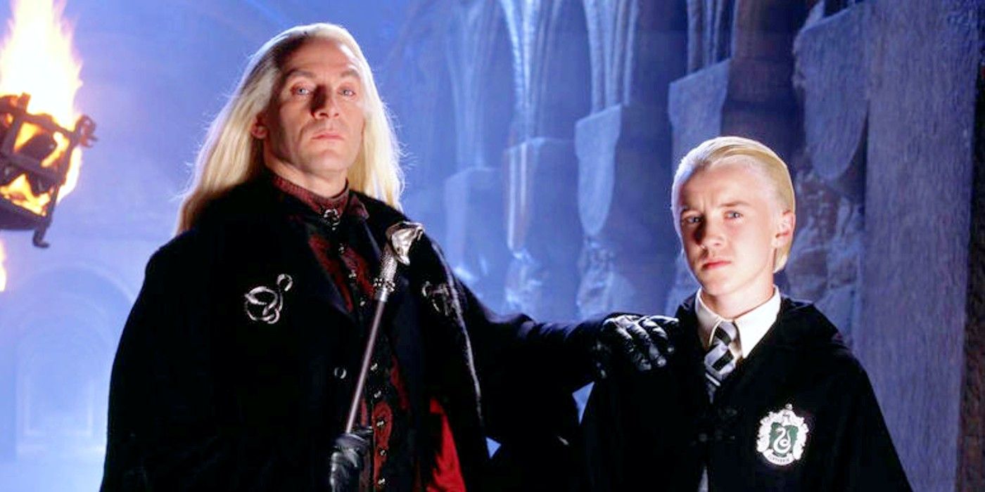 Lucius Malfoy stands with his hand on Draco's shoulder in Harry Potter.