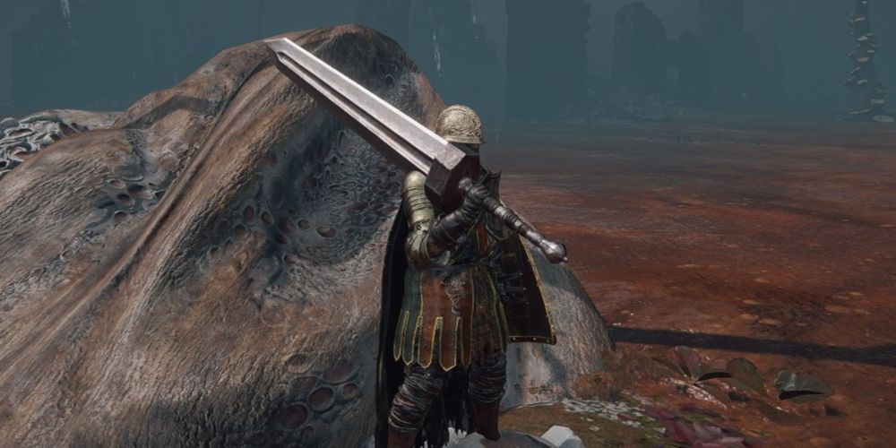 A Tarnished with a Strength build wielding a Colossal Sword in Elden Ring