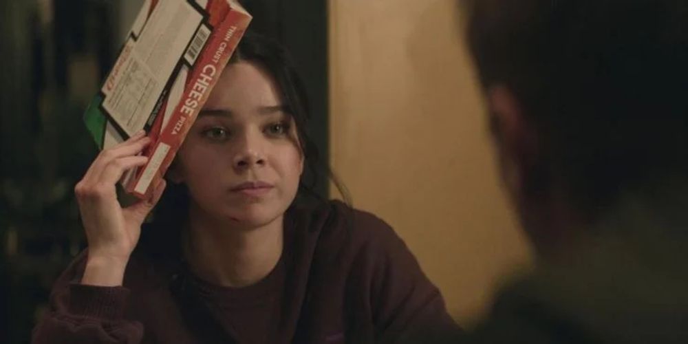 Kate Bishop talking to Clint Barton with a cold pizza on her head in Hawkeye.