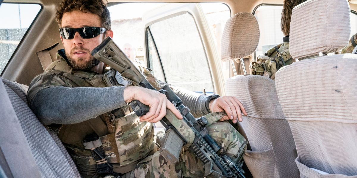Clay with a gun in the backseat of a car on SEAL Team.