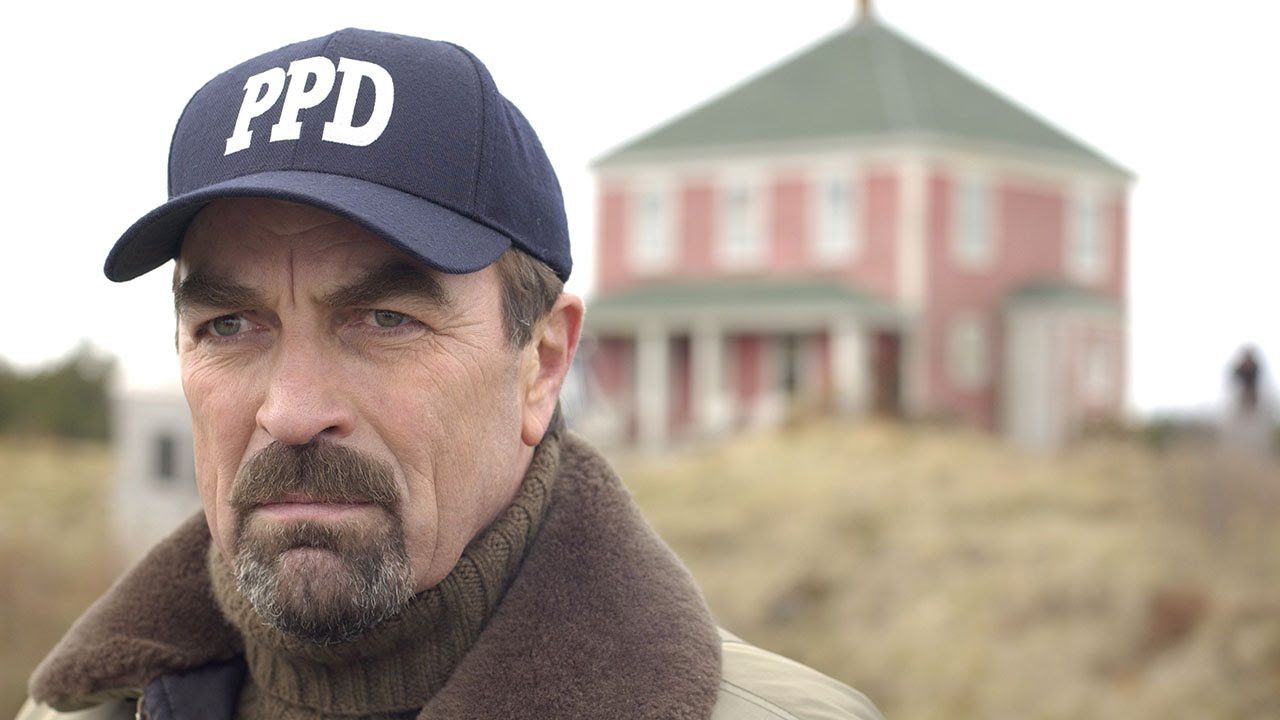 Tom Selleck como Jesse Stone na frente de uma casa em uma cena de Stone Cold