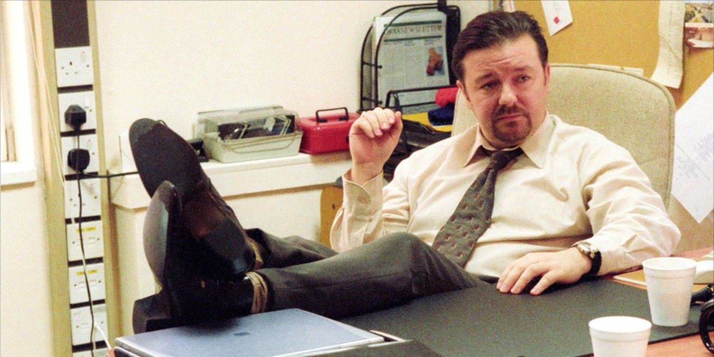 Ricky Gervais as David Brent in The Office, with his feet up on his desk