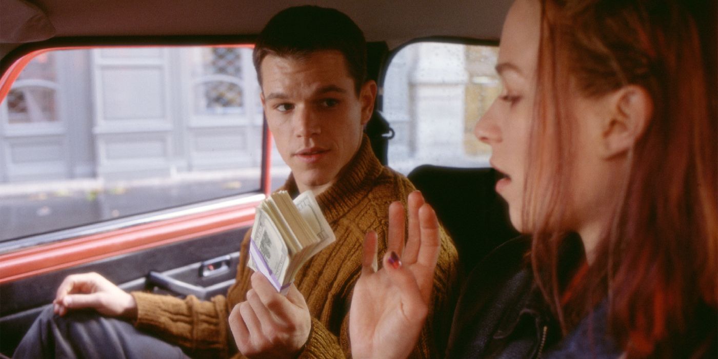 Jason Bourne handing Marie a stack of money in The Bourne Identity.