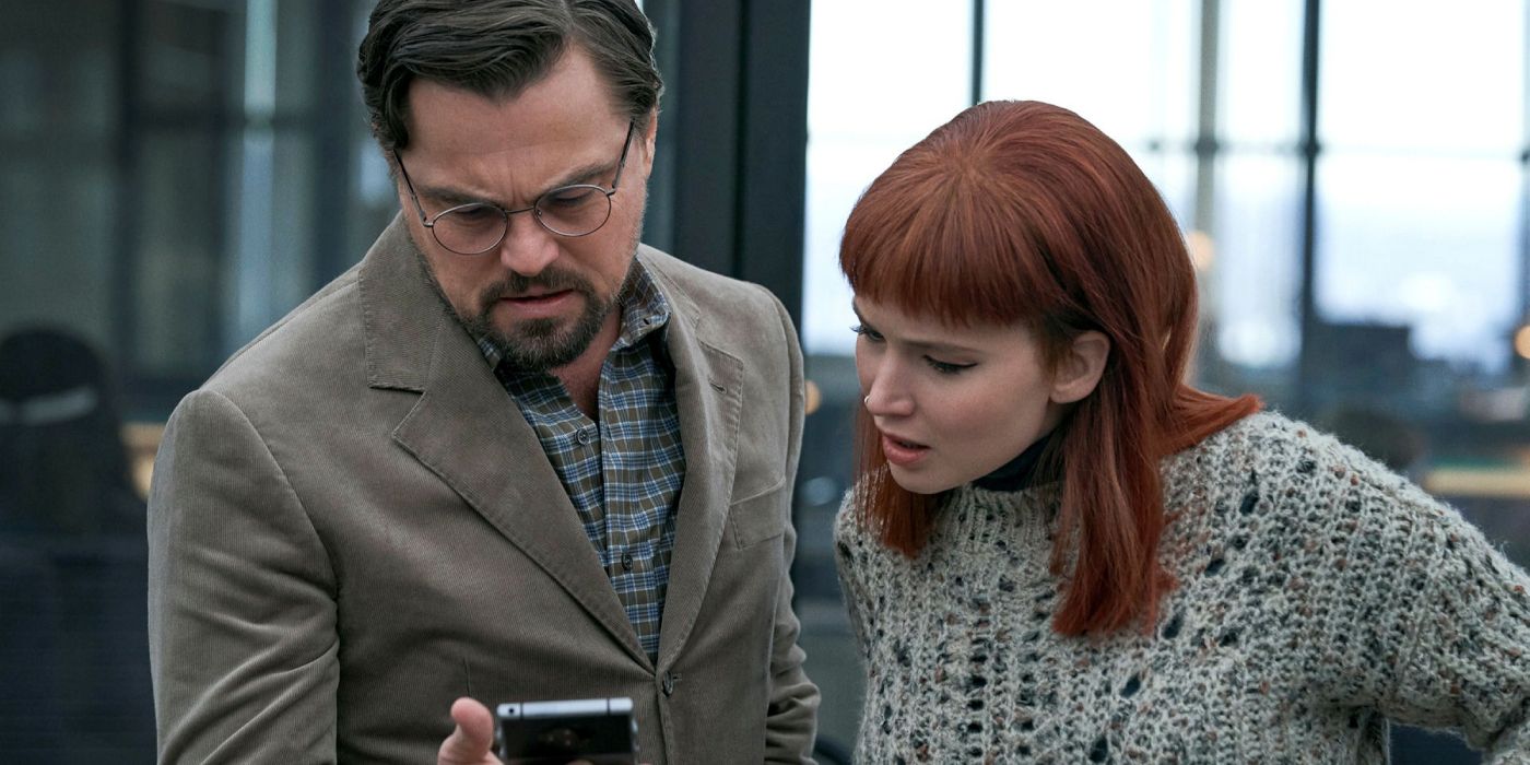 Leonardo Dicaprio and Jennifer Lawrence look down at a phone in Don't Look Up
