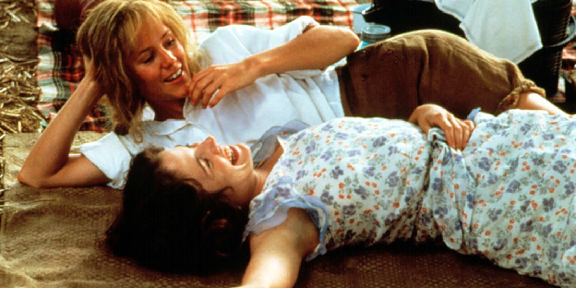 Idgie (Mary Stuart Masterson) e Ruth (Mary-Louise Parker) deitadas em um cobertor e rindo em Fried Green Tomatoes.