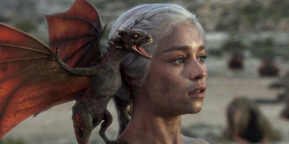 A newly hatched dragon stands on Daenerys Targaryen's shoulder in Game of Thrones.