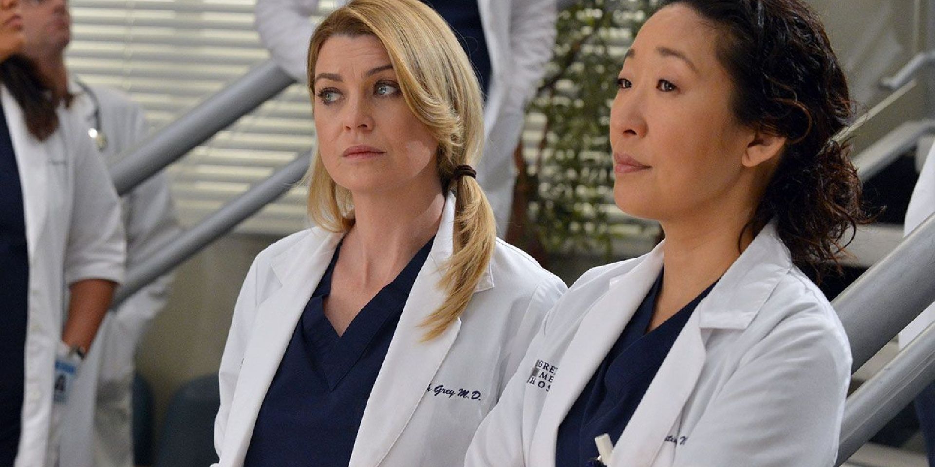 Meredith and Cristina stand in the hospital in Grey's Anatomy