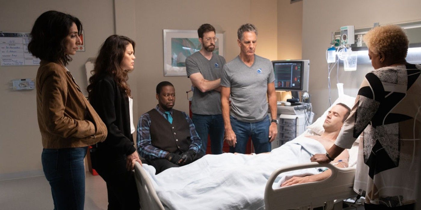 The cast of NCIS: New Orleans surrounding Christopher on his deathbed in the hospital