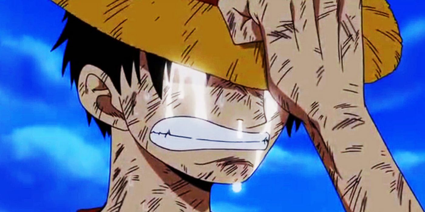 One Piece Luffy chorando enquanto segura o chapéu no lugar