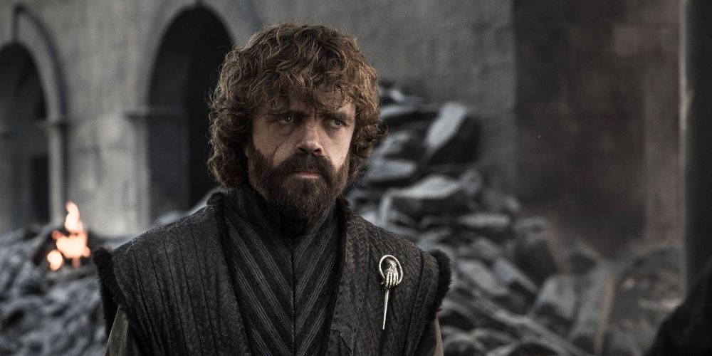 Tyrion Lannister looking somber while in front of debris