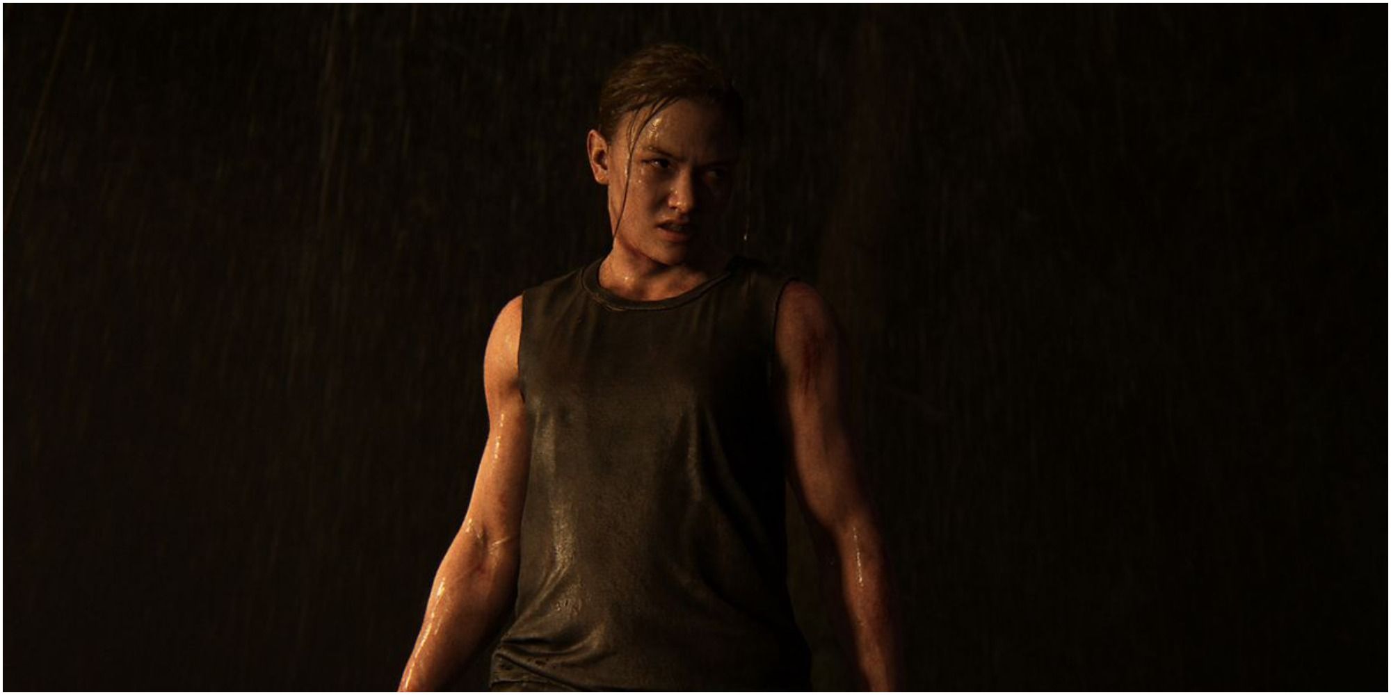 Abby from The Last Of Us Part II stands in firelight.