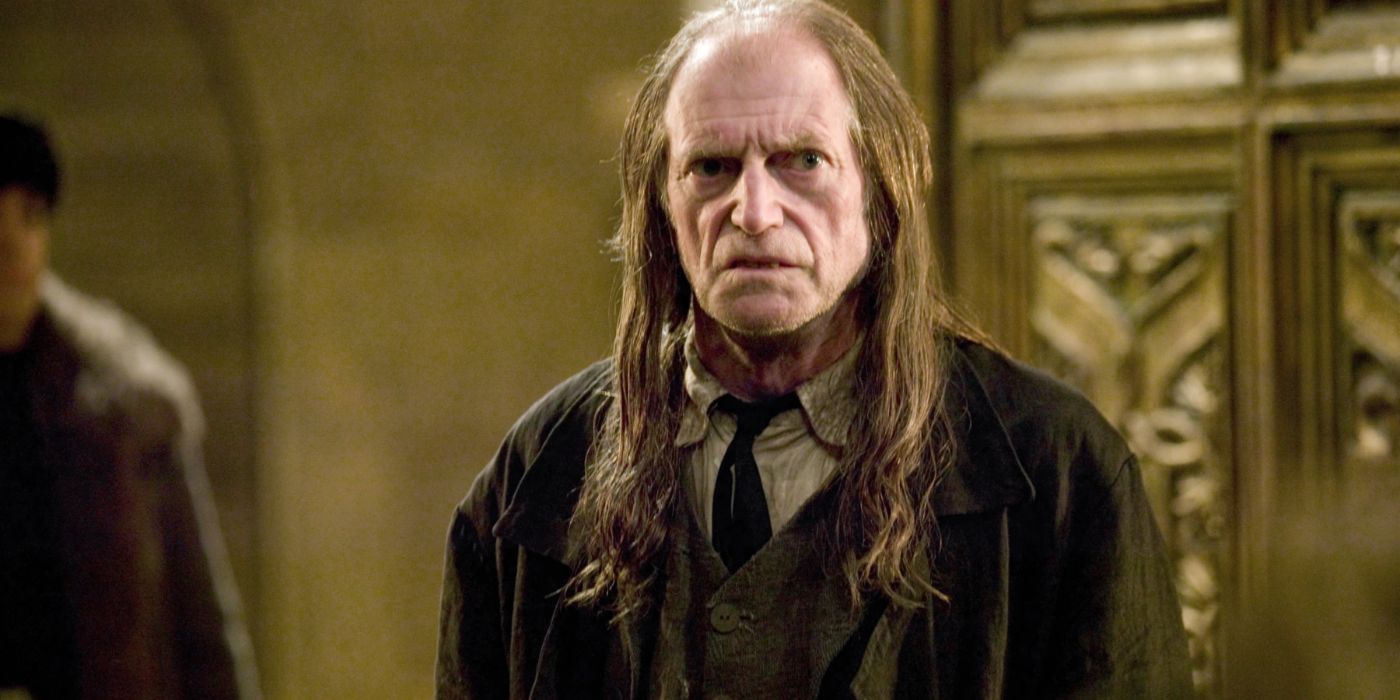 Argus Filch olhando para algo em Harry Potter.