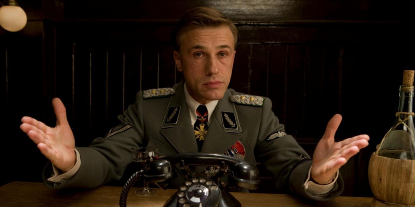 Hans Landa sitting at a table during the opening scene of Inglourious Basterds