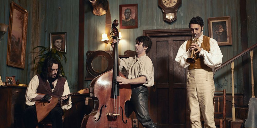 Jemaine Clement, Jonathan Brugh and Jemaine Clement playing music in What We Do in the Shadows