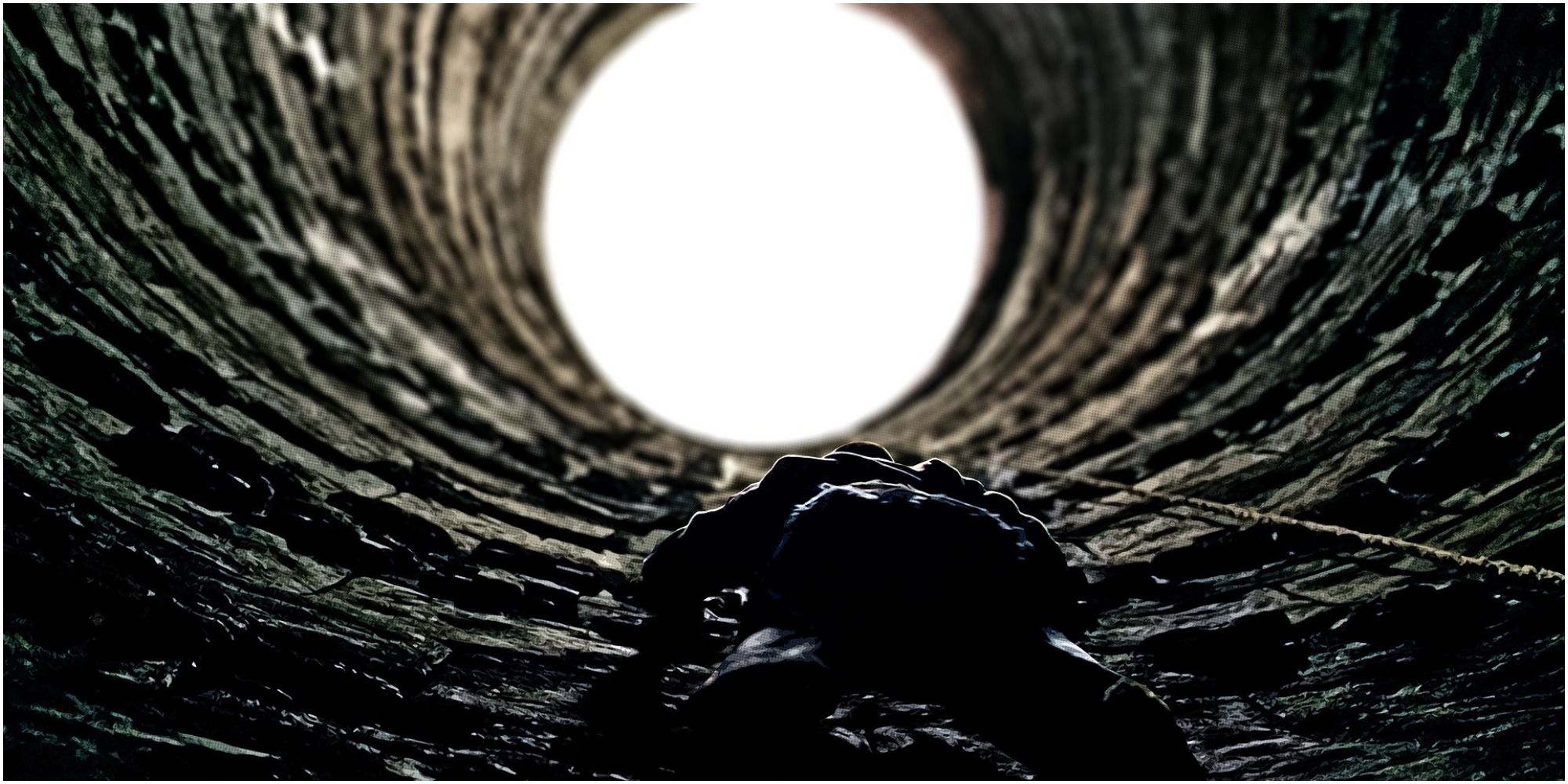 Christian Bale as Bruce Wayne Climbing Out of a hole
