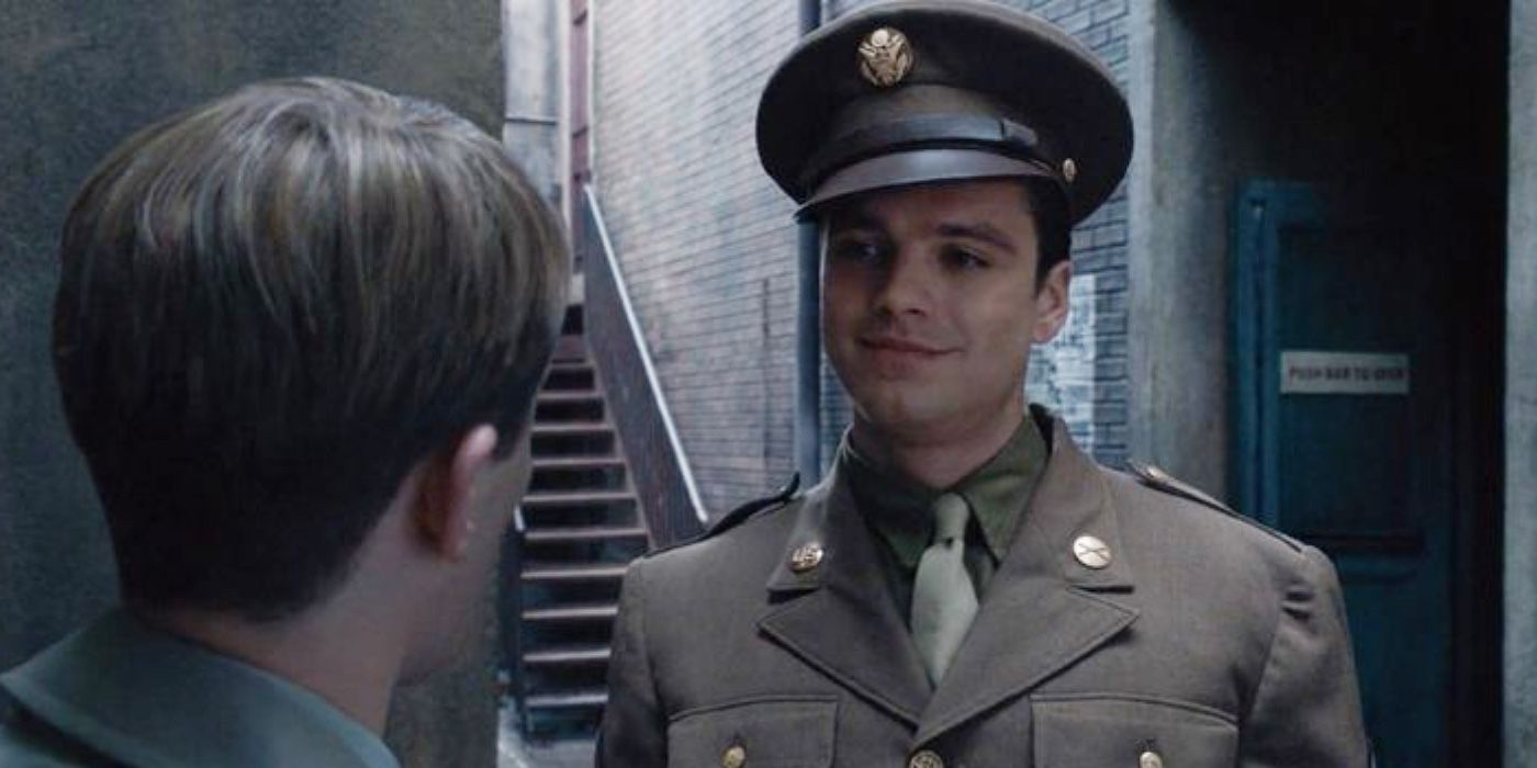 Bucky Barnes, played by Sebastian Stan, is smiling at Steve Rogers, portrayed by Chris Evans, in Captain America: The First Avenger
