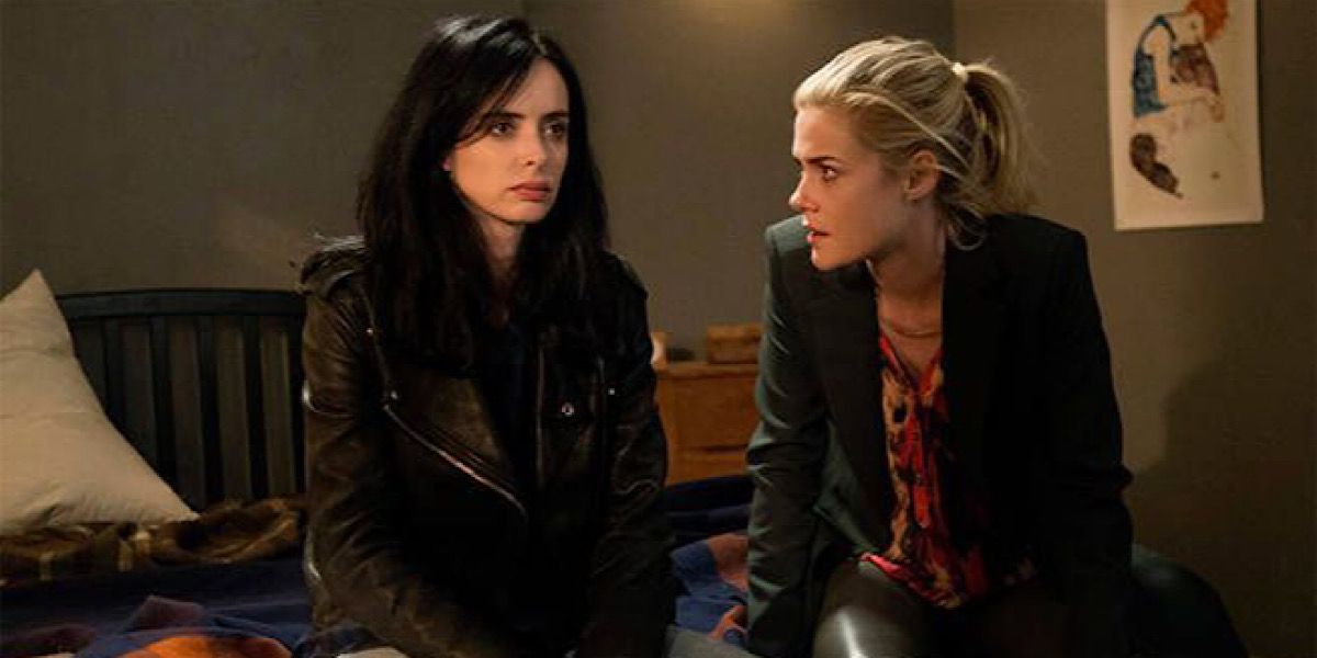 Jessica Jones and Trish Walker sitting on the bed and talking in Jessica Jones