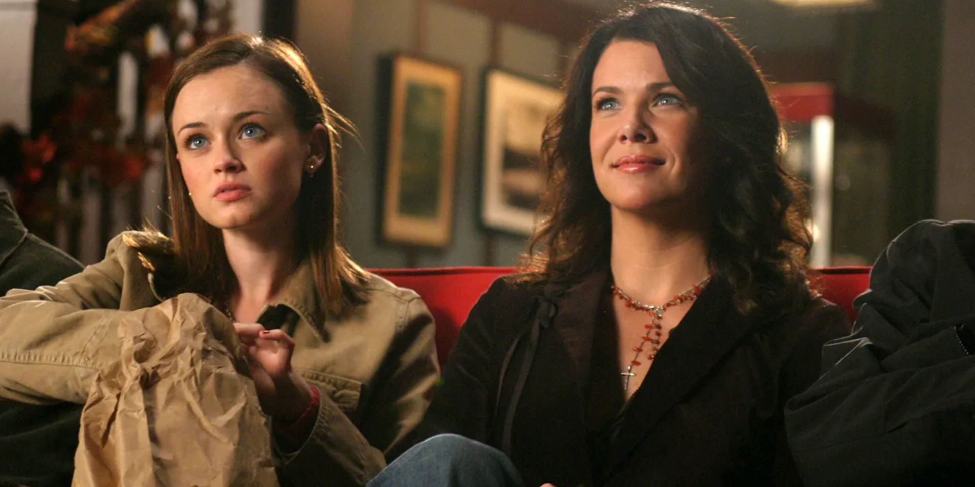 Lorelai Gilmore sits in Gilmore Girls with her daughter Rory.