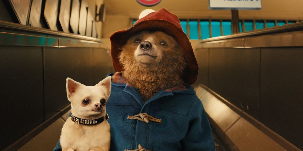 Paddingon Bear going down the escalator with a dog in Paddington movie
