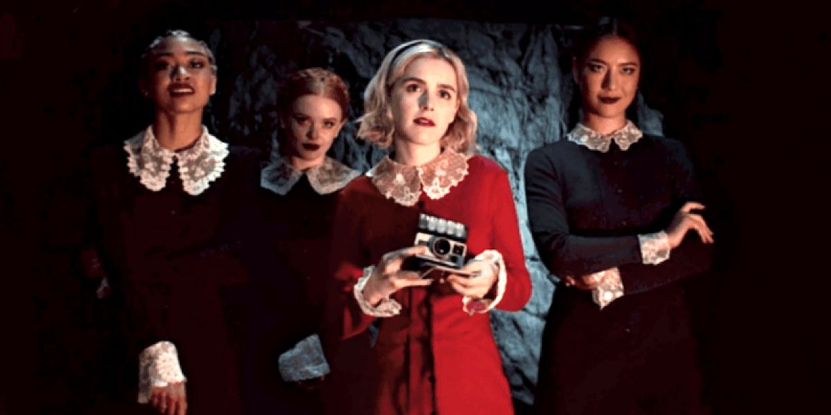 Sabrina Spellman takes a picture alongside the Weird Sisters in Chilling Adventures of Sabrina