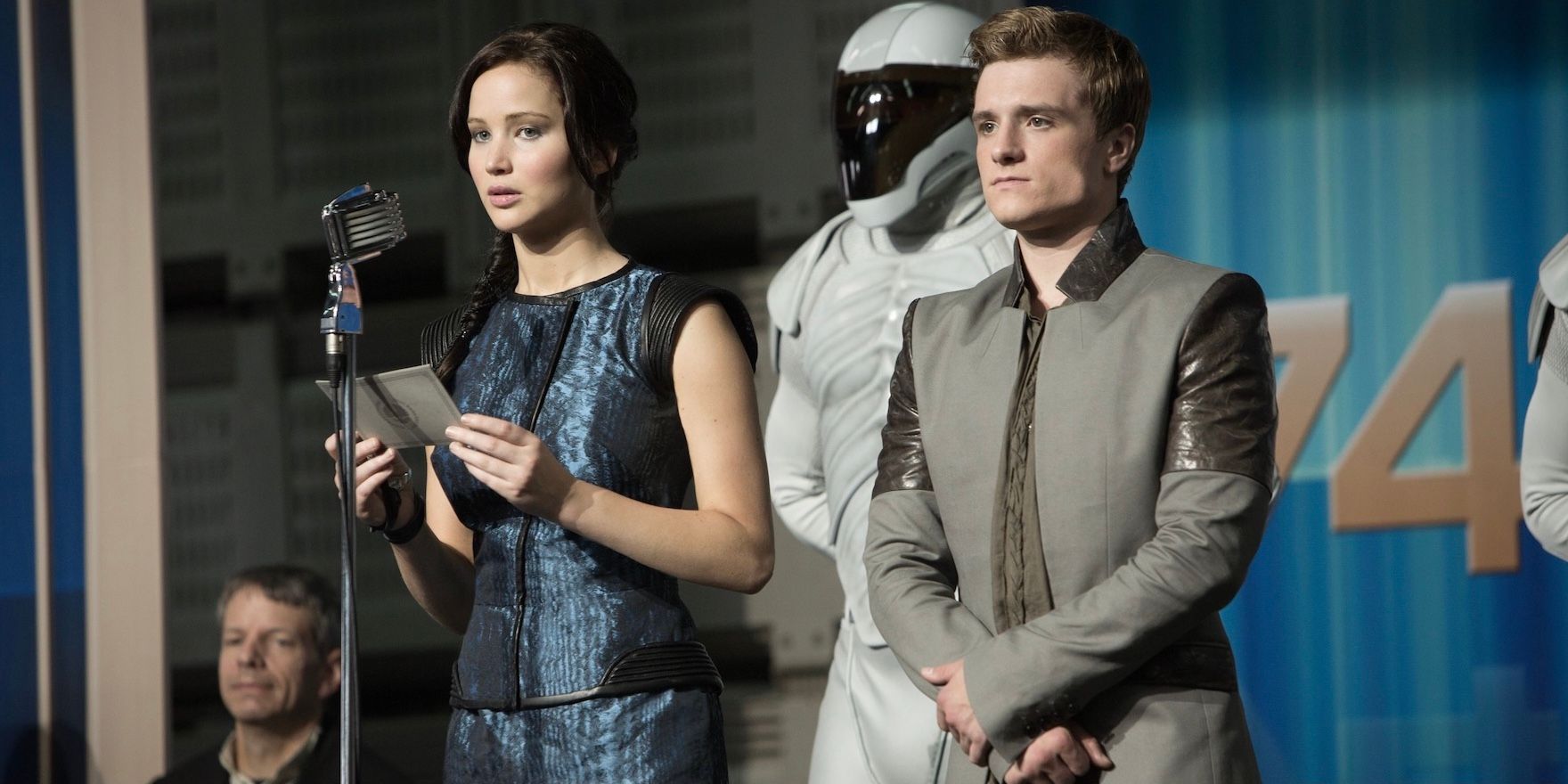 Katniss Everdeen (Jennifer Lawrence) and Peeta Mellark (Josh Hutcherson) giving a reluctant speech in The Hunger Games: Catching Fire.