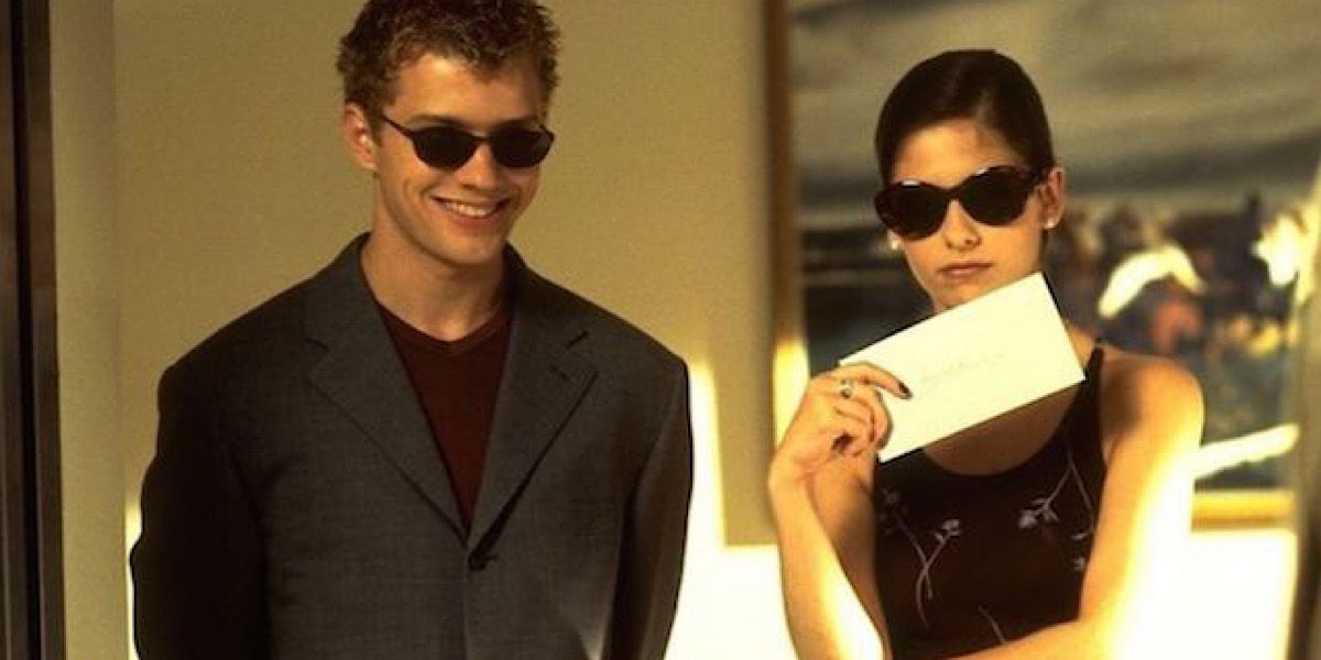 Sebastian and Kathryn wearing sunglasses and holding a letter