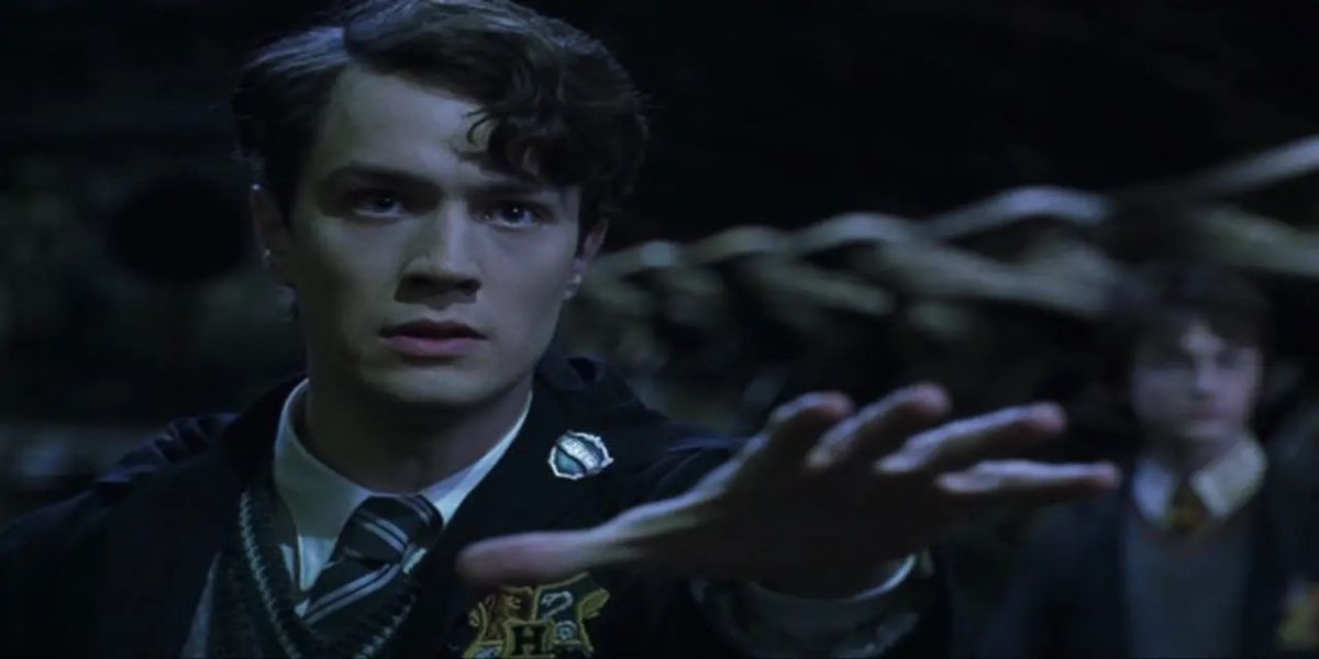 Tom Riddle com a mão estendida e Harry atrás dele em Harry Potter e a Câmara Secreta