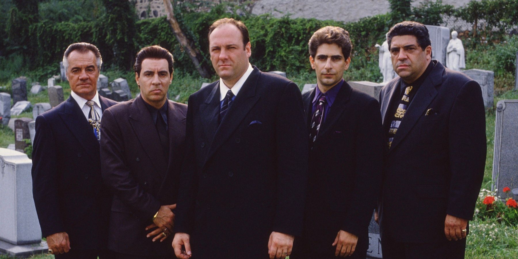 Tony Soprano and his associates stand in a graveyard facing the camera 