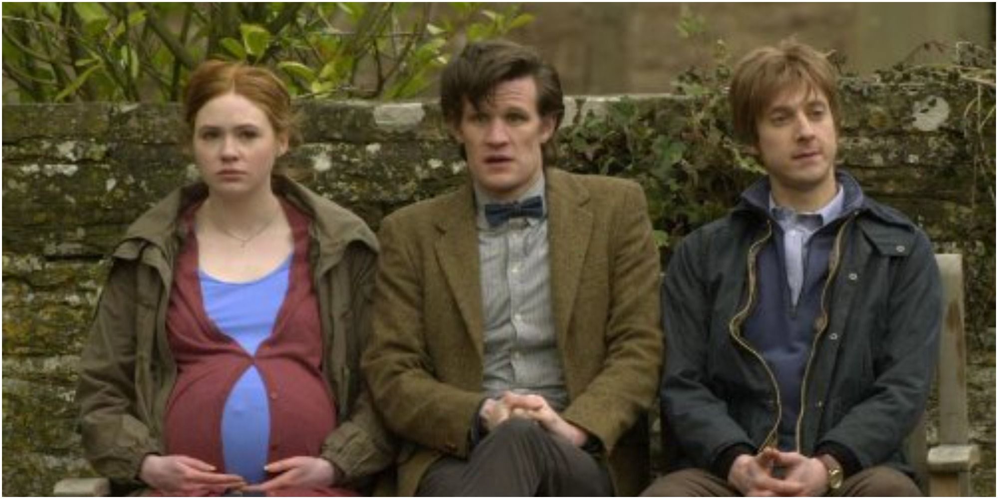 The Eleventh Doctor and the Ponds sit on a bench in Doctor Who. Amy is pregnant.