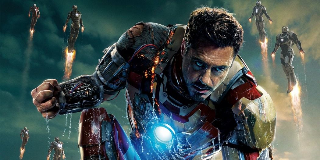 Tony Stark in his Iron Man suit sans helmet, damaged while multuple Iron Man robots fly around him on the poster for Iron Man 3
